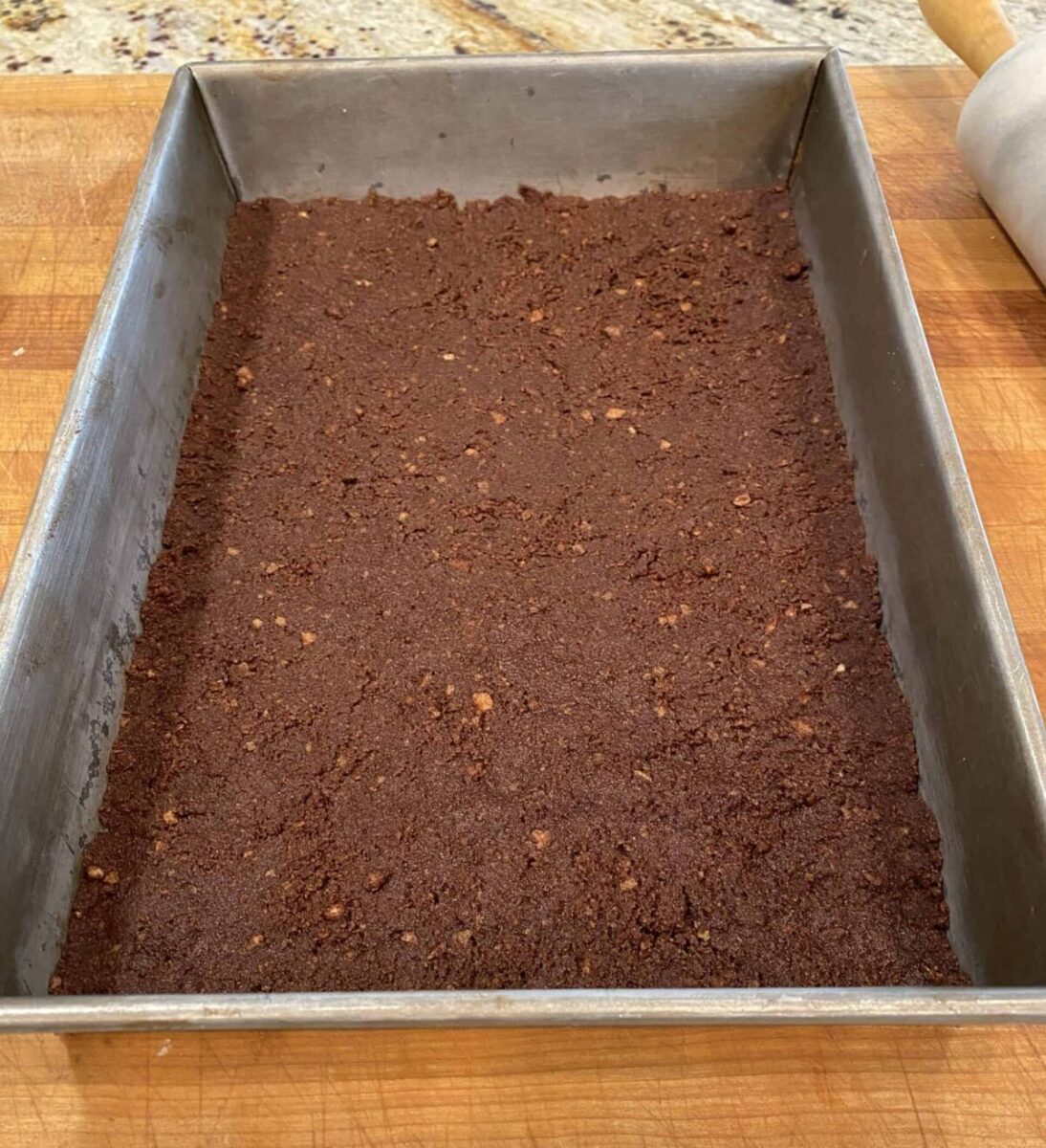 Chocolate vanilla wafer crust in a baking pan.