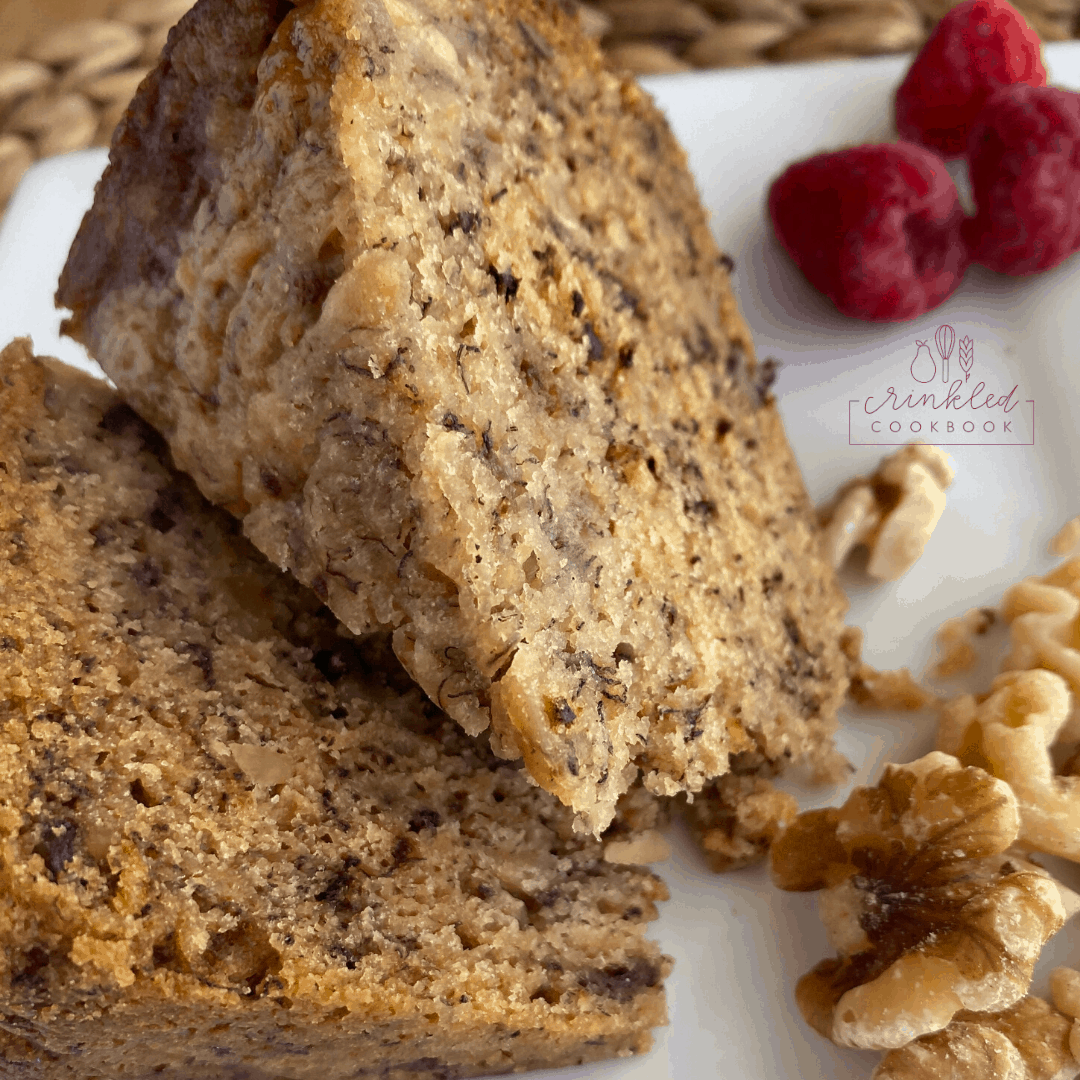 Wedges of banana bread with nuts and raspberries in the background