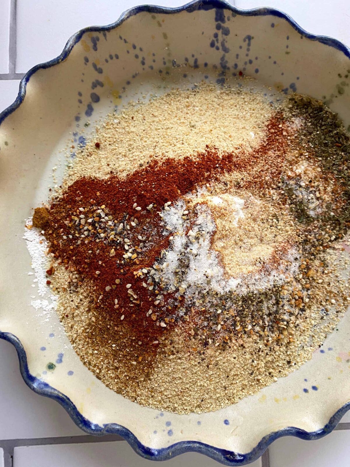 The spice ingredients for chicken strips in a shallow dish