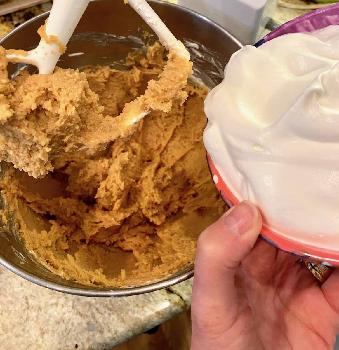 Adding whipped cream to the peanut butter and cream cheese in a mixing bowl