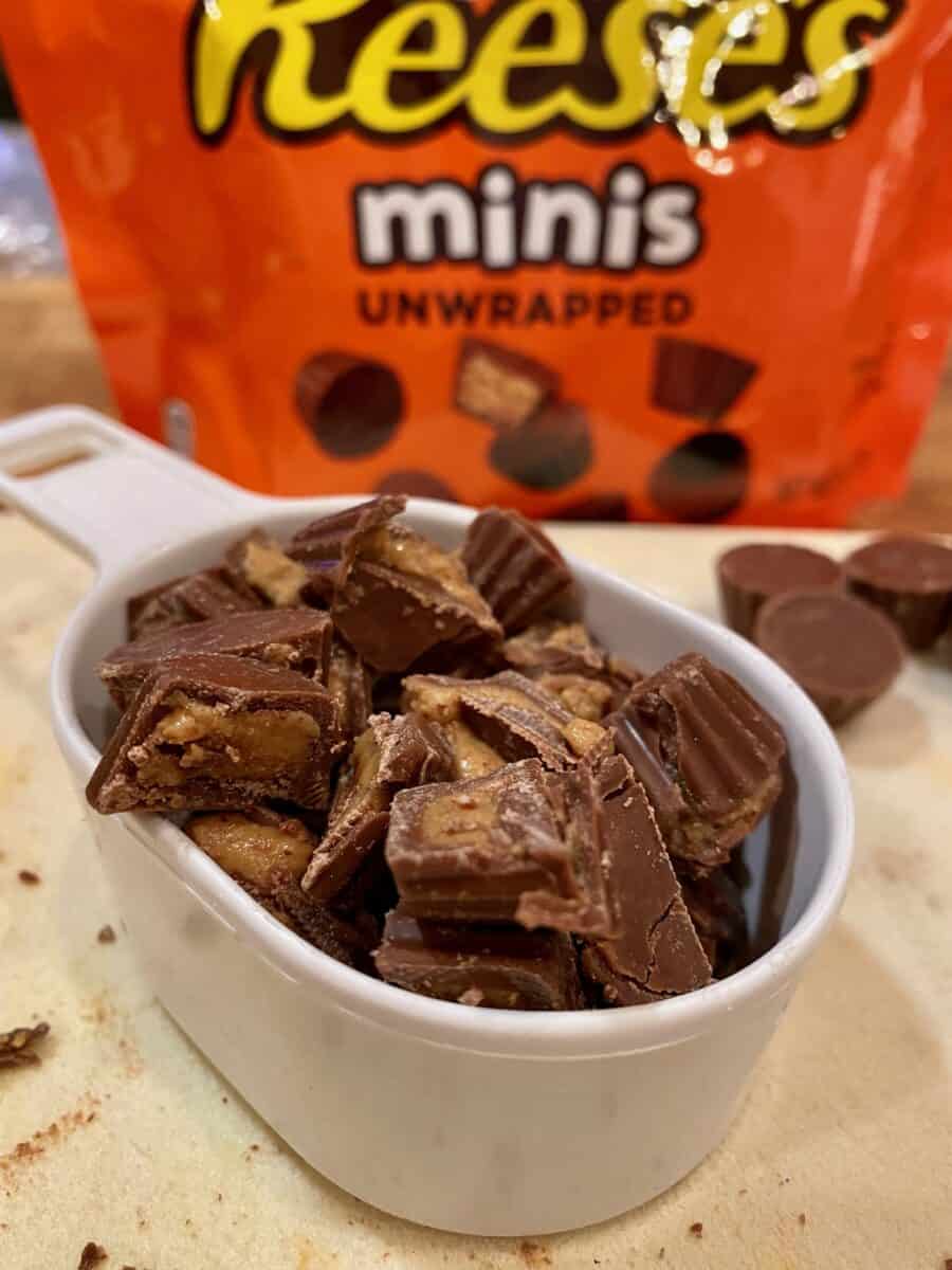 A measuring cup with Resse's minis and a package of the candy in the background