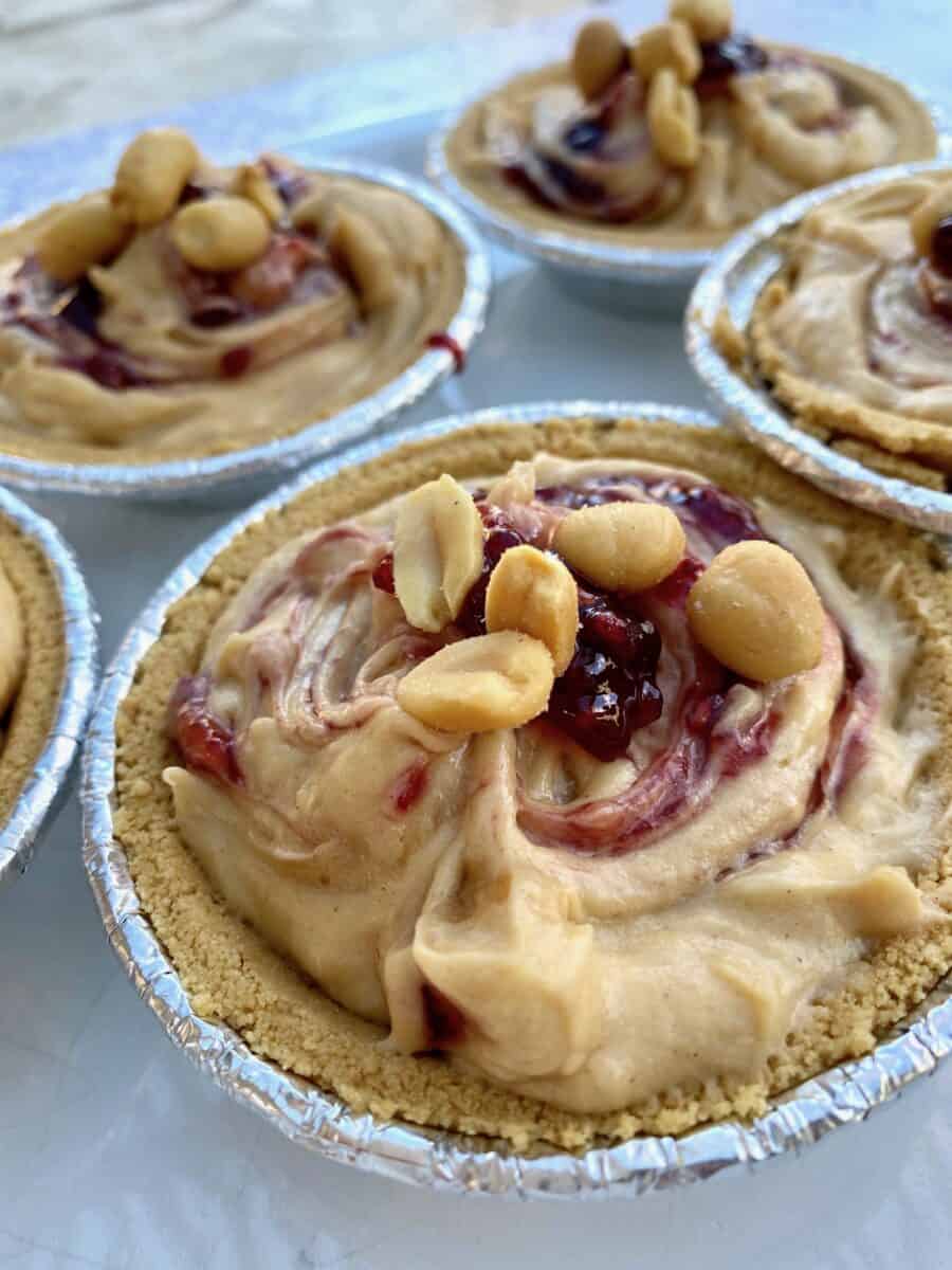 Several peanut butter and jam pies in small pie pans