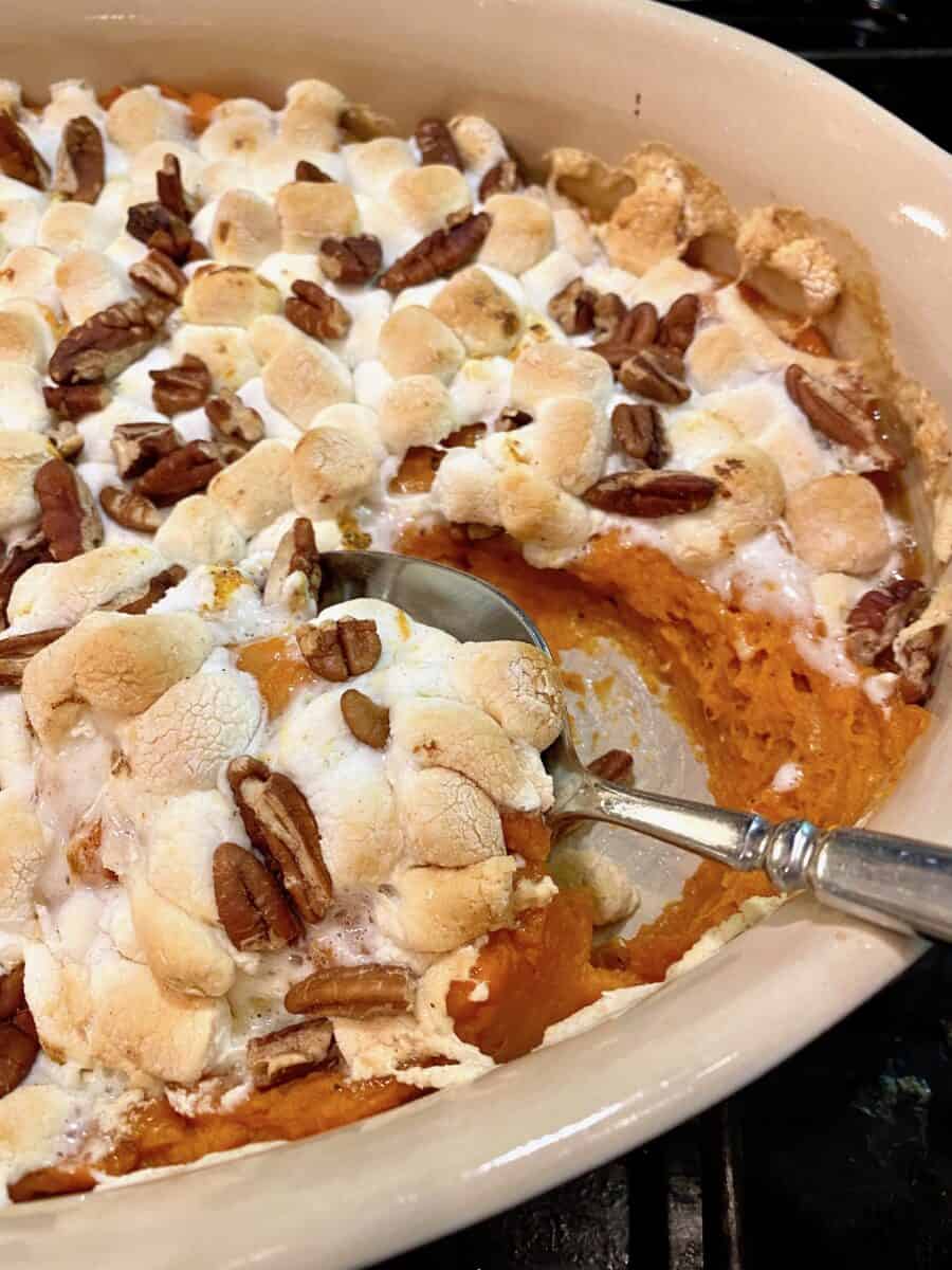 Sweet potato casserole in a baking dish with a spoon 