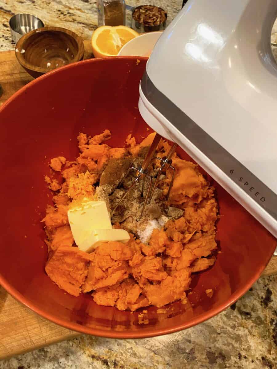 Casserole ingredients in a large bowl with a hand mixer