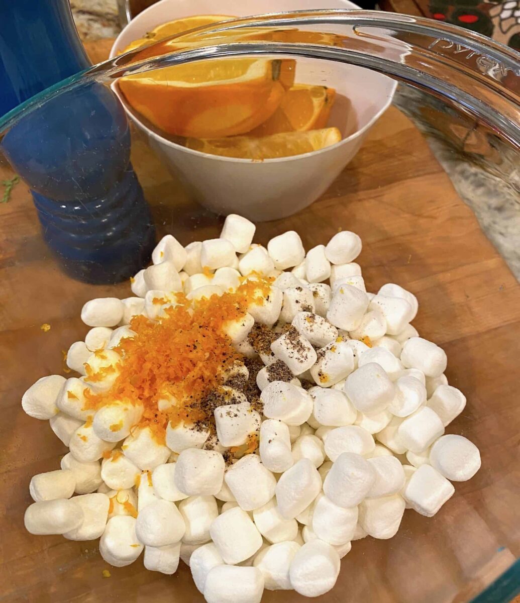 Mini marshmallows in a bowl with orange zest and pepper