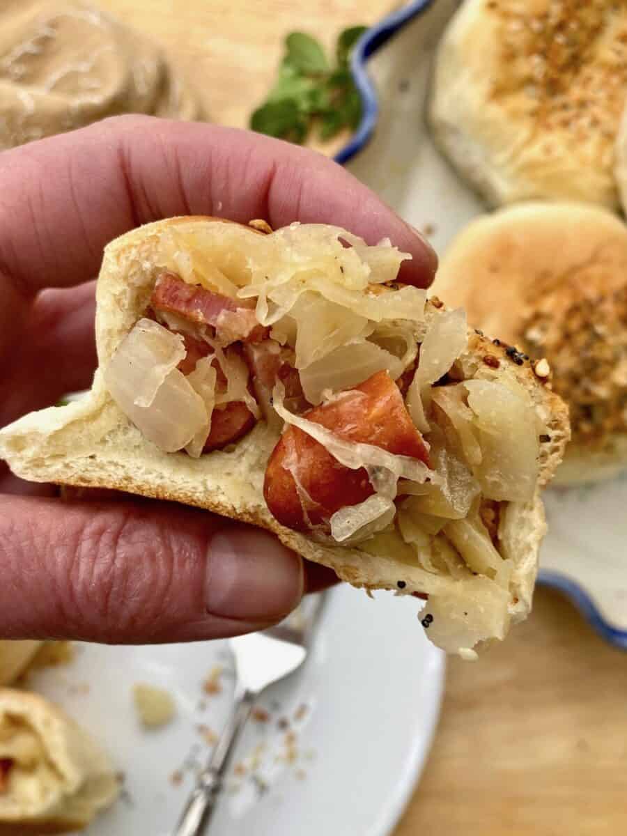 Pig in a blanket cut in half and held in someone's hand