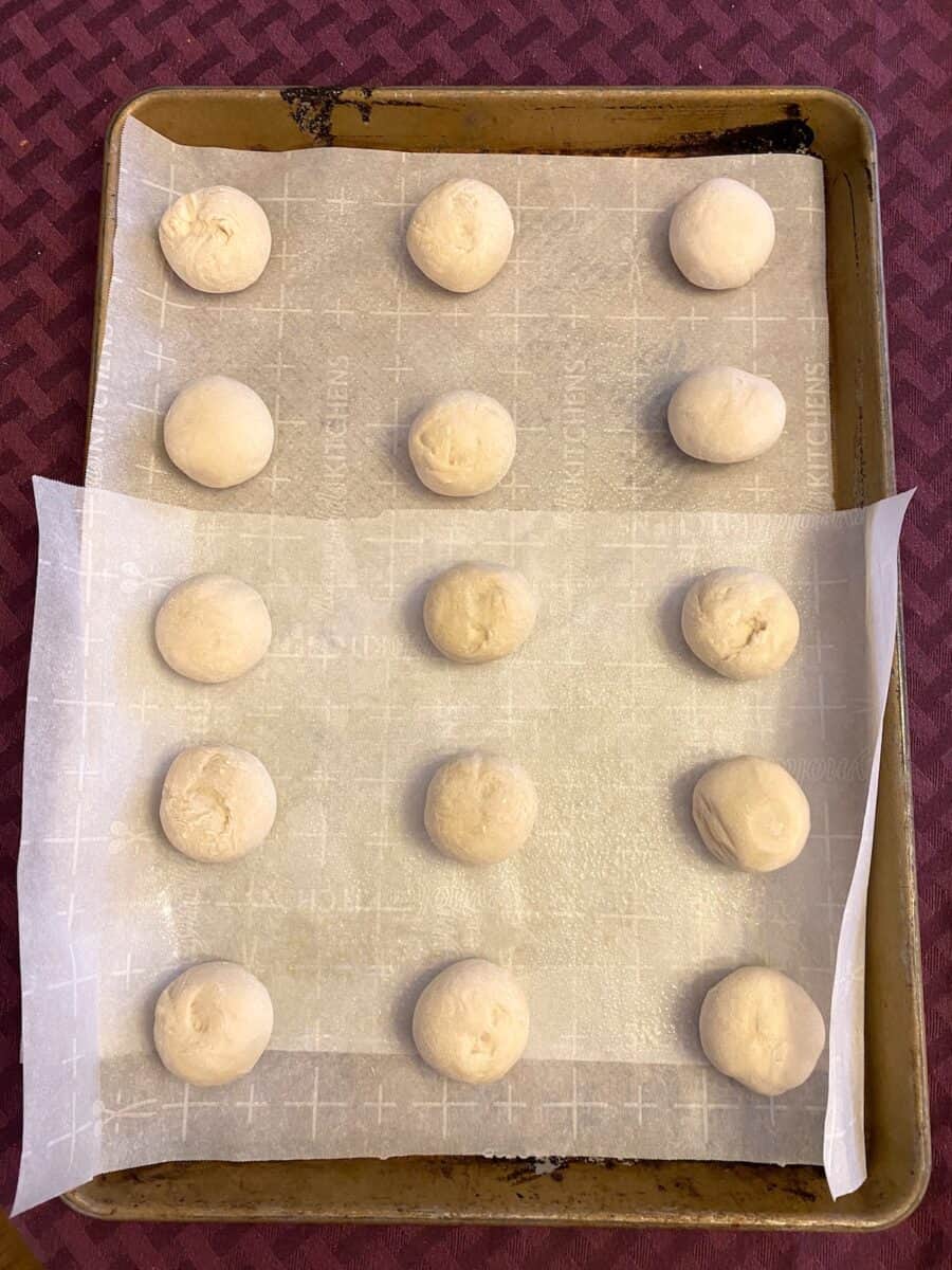 Frozen Rhodes dinner rolls placed in rows on a baking sheet