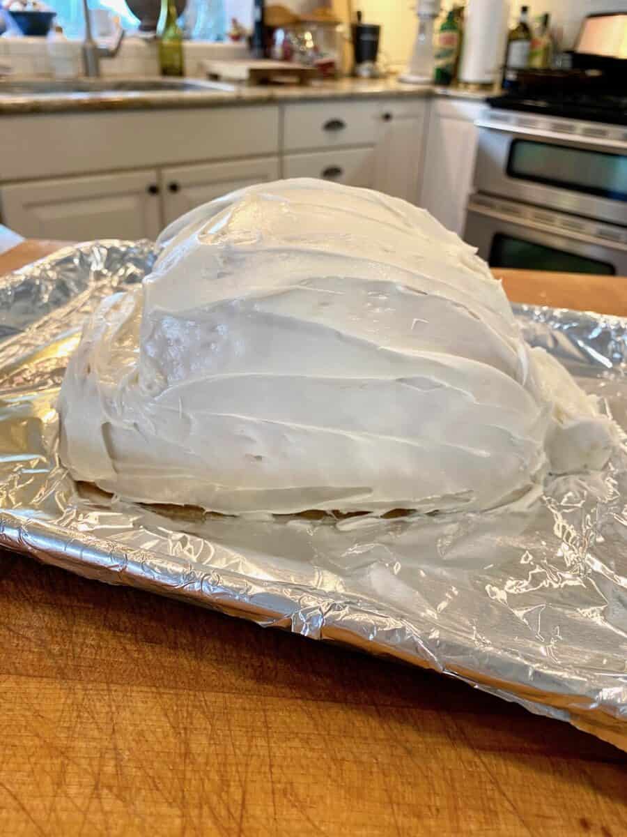 Frosted bunny cake on a foil baking sheet. 