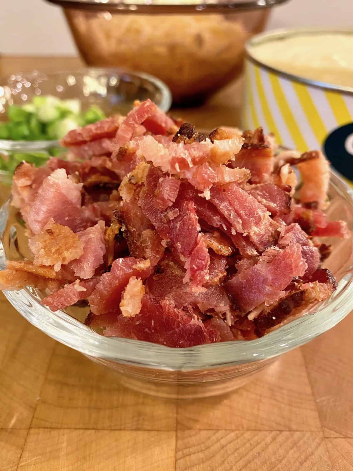 A bowl of cooked and diced bacon.