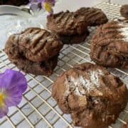 Molasses Snaps cookies on a cooling rack with a pansy on the side.