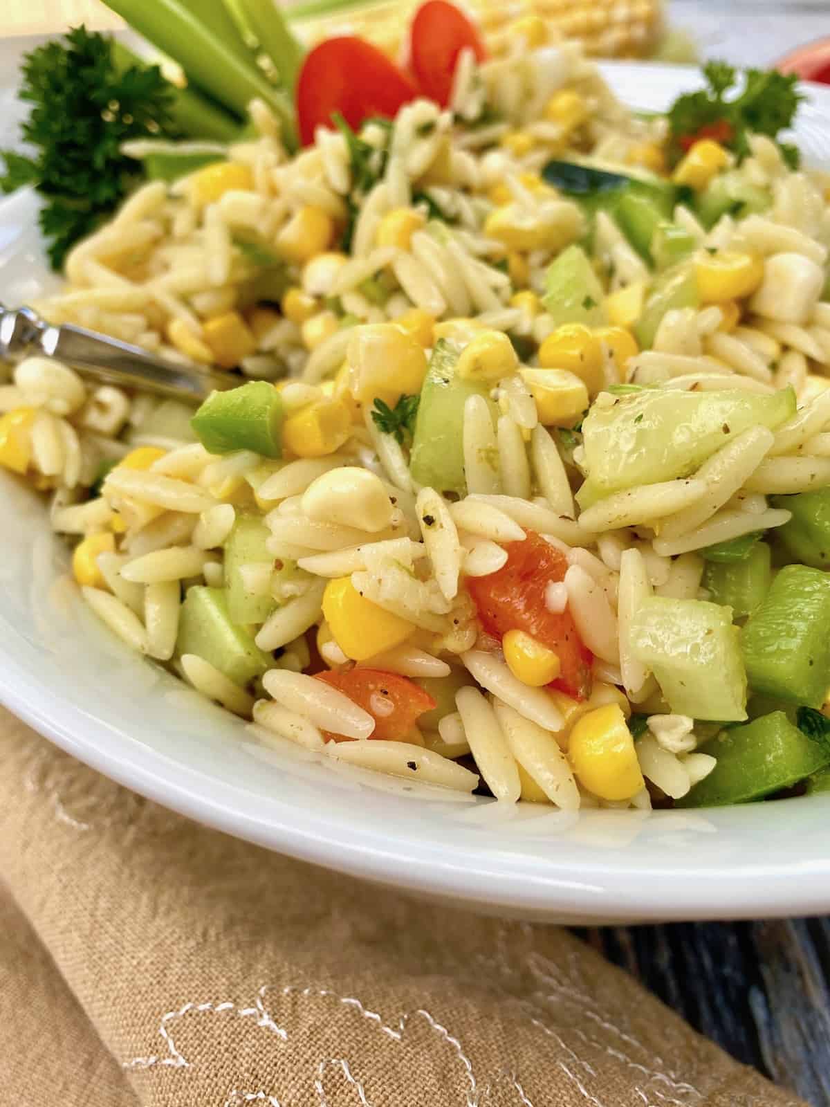 A bowl of sweet corn pasta salad.