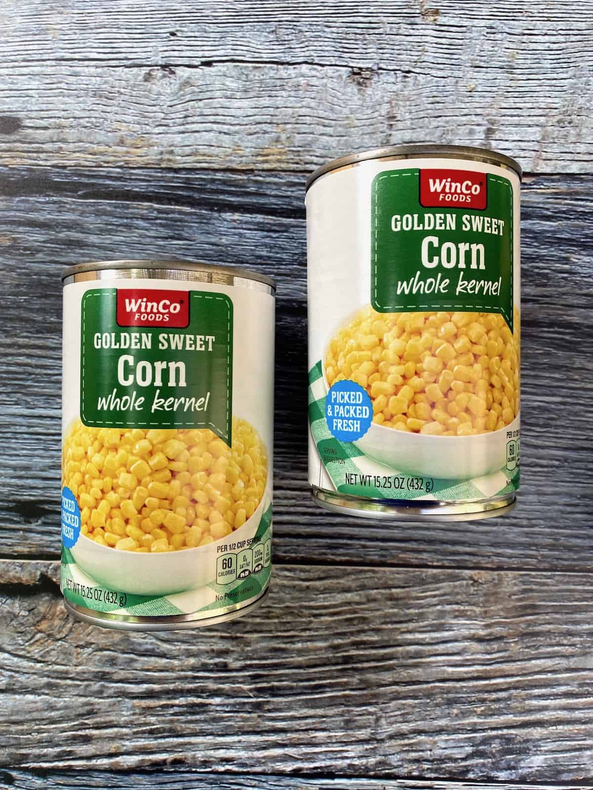 Two cans of whole kernel corn. 