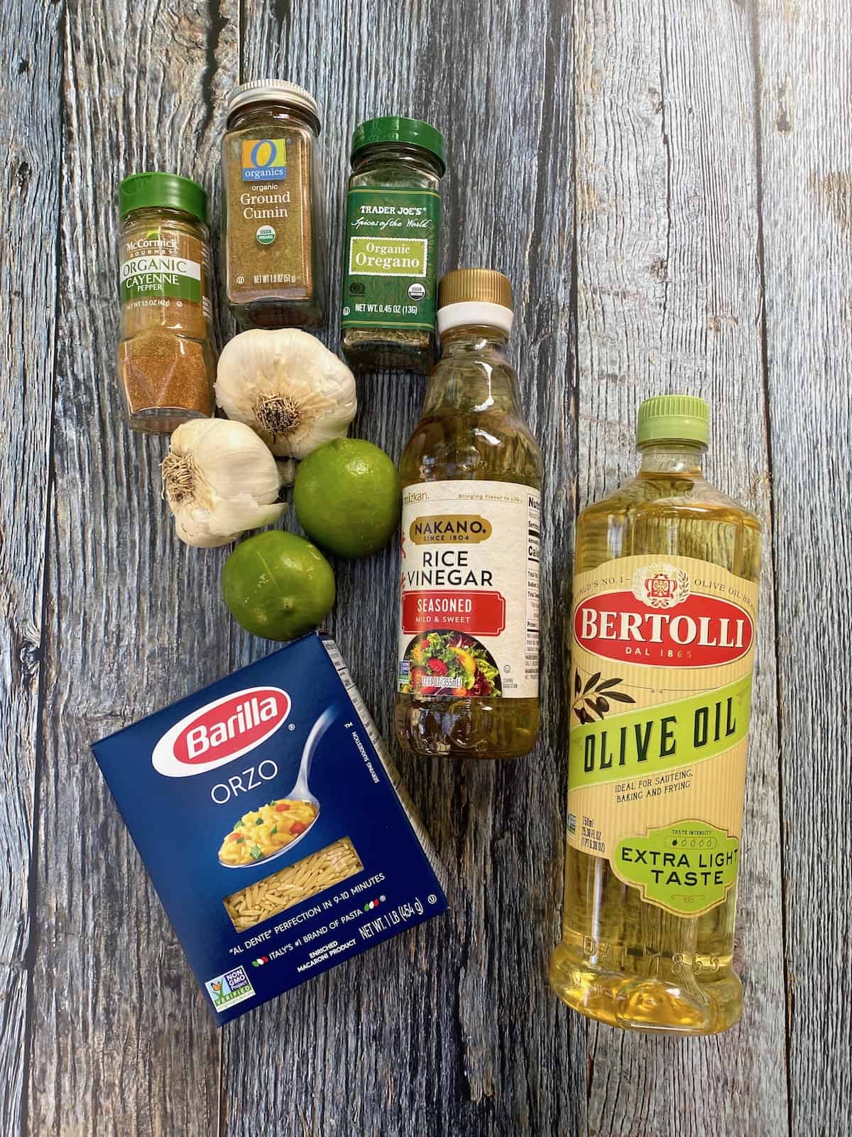 Salad dressing ingredients including a box of pasta, spices and olive oil and vinegar for sweet corn pasta salad.