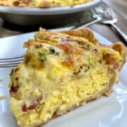 A wedge of quiche on a serving plate.