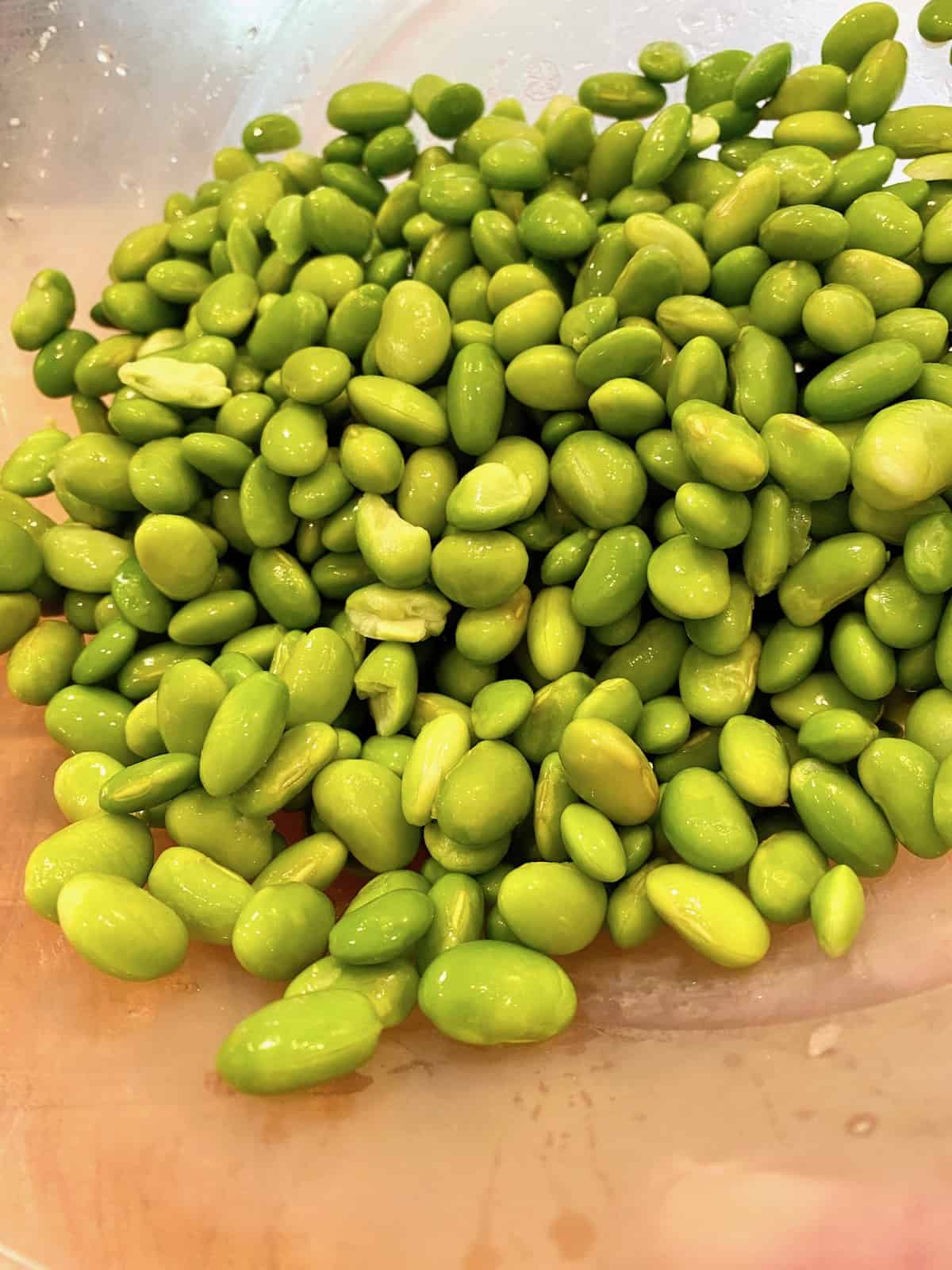 A mound of edamame on a cutting board. 