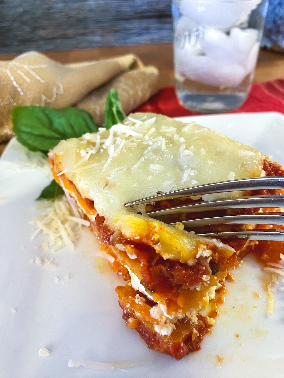 A wedge of sweet potato lasagna with a fork. 