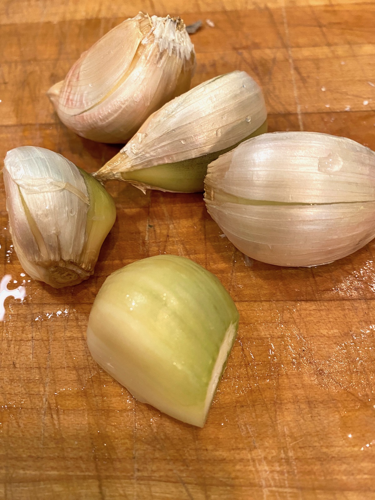 Elephant garlic cloves on a cutting board.