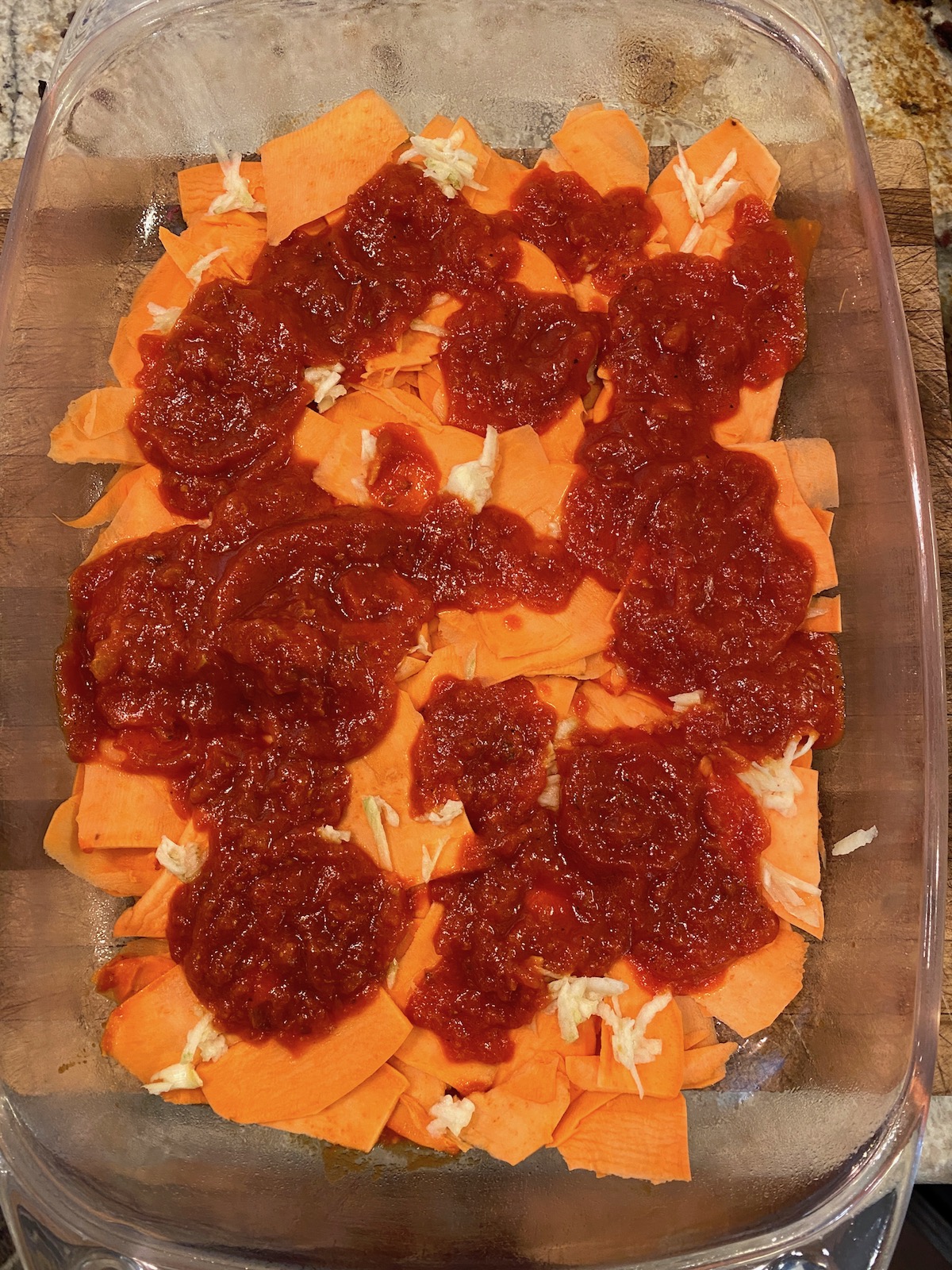 Marinara sauced placed on top of sliced sweet potatoes.