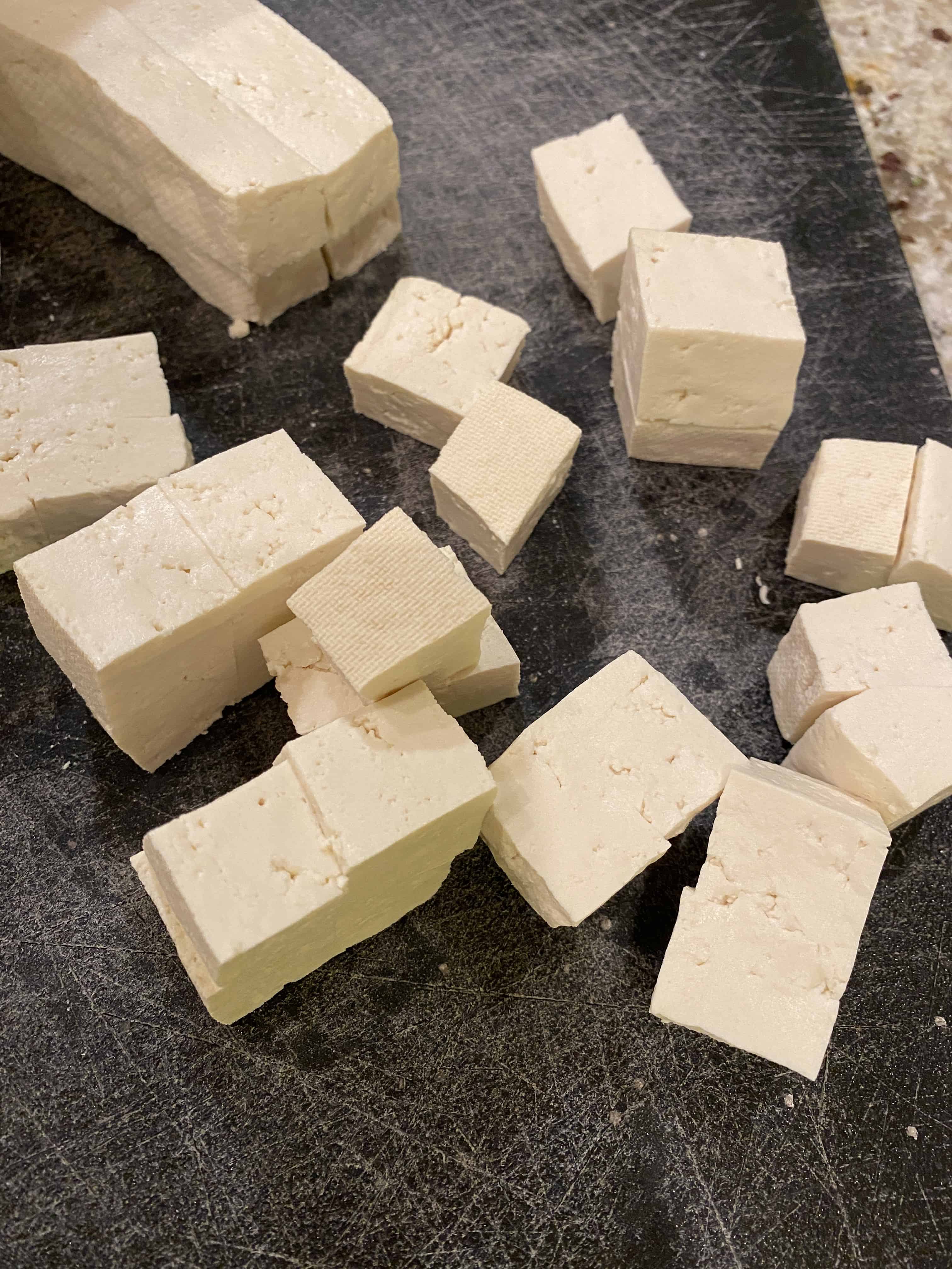 Diced tofu on a cutting board.