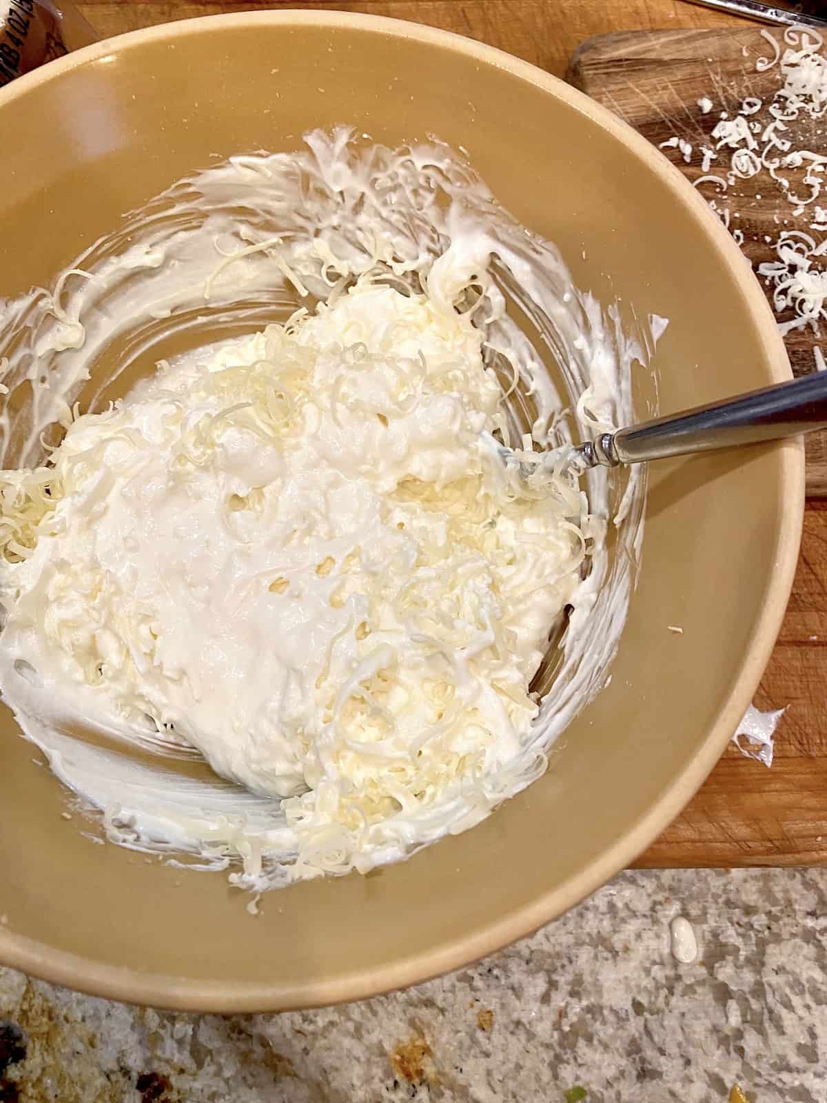 Creamy ingredients in a small bowl with a spoon.