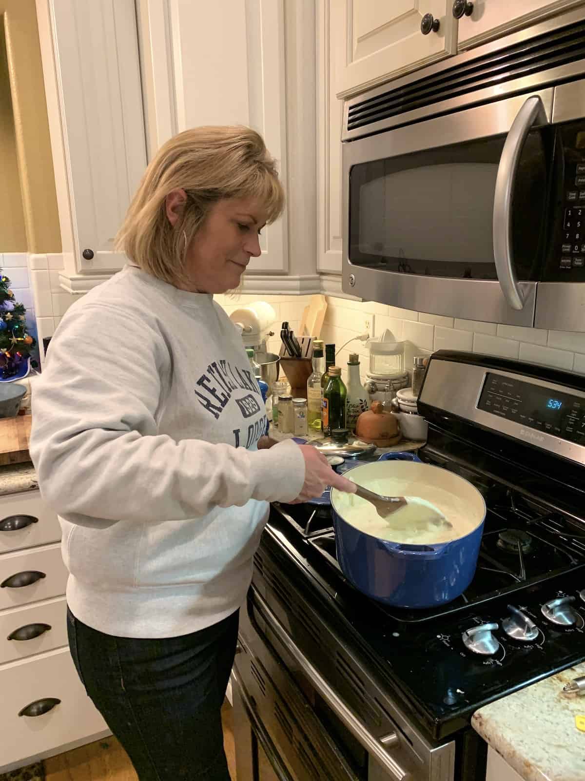 Melinda stirring clam chowder at the stove.