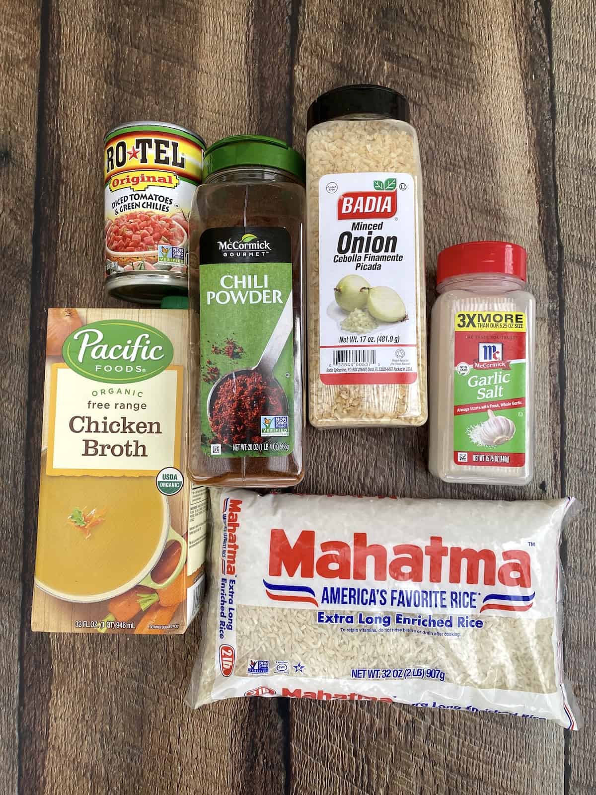 Ingredients for Mexican rice displayed on wooden table.