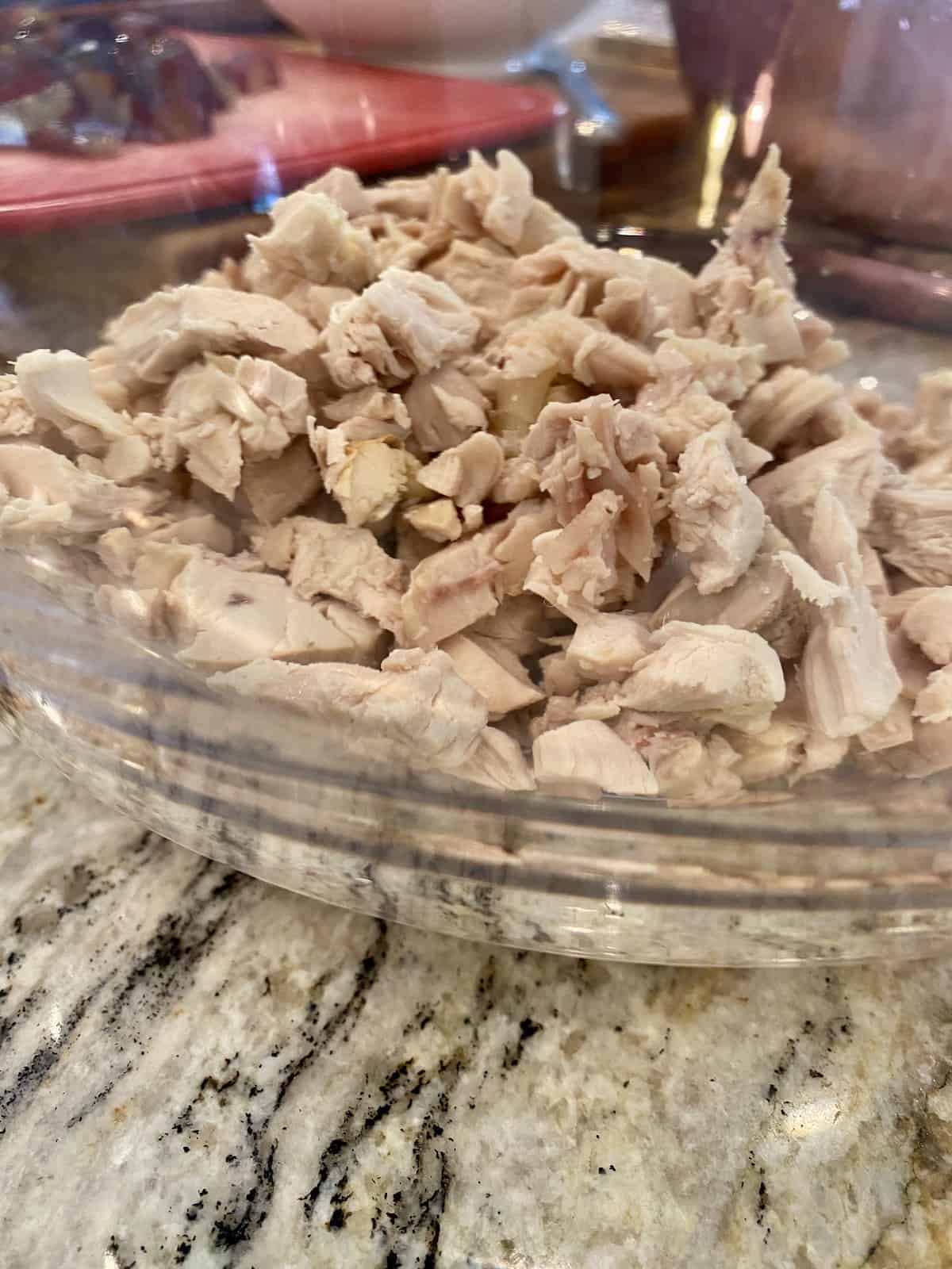 Diced and shredded cooked chicken in a bowl.