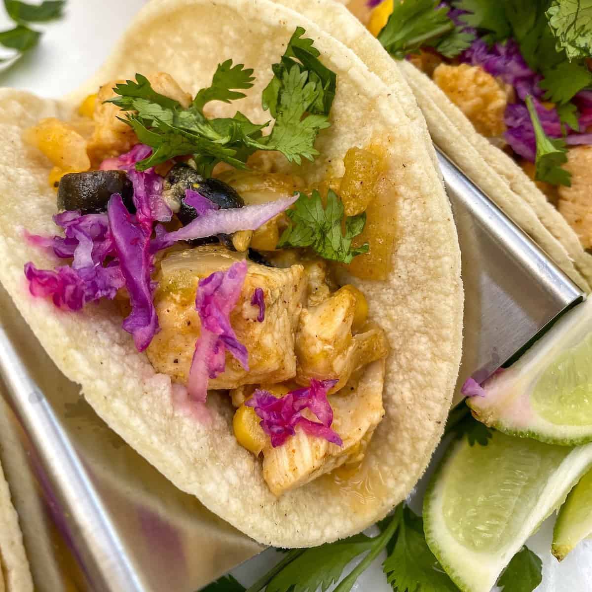 Chicken Street Tacos on a plate with lime and cilantro.