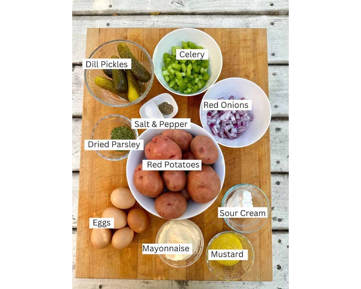 Red potato salad ingredients on a cutting board with labels on each ingredient.