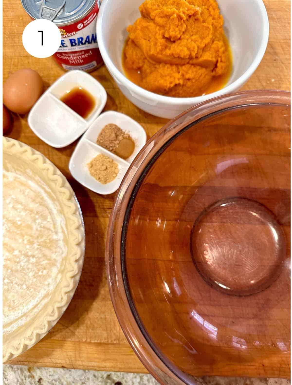 Ingredients for pumpkin pie on a cutting board.