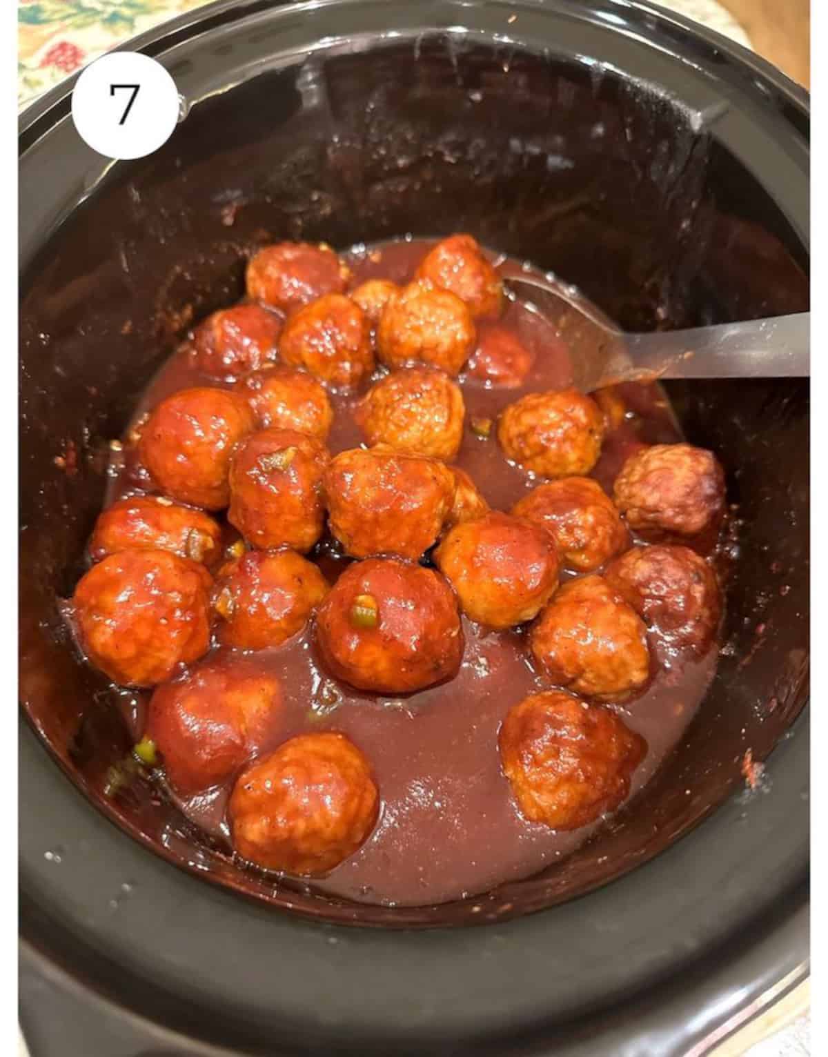 Meatballs and sauce in a slow cooker.