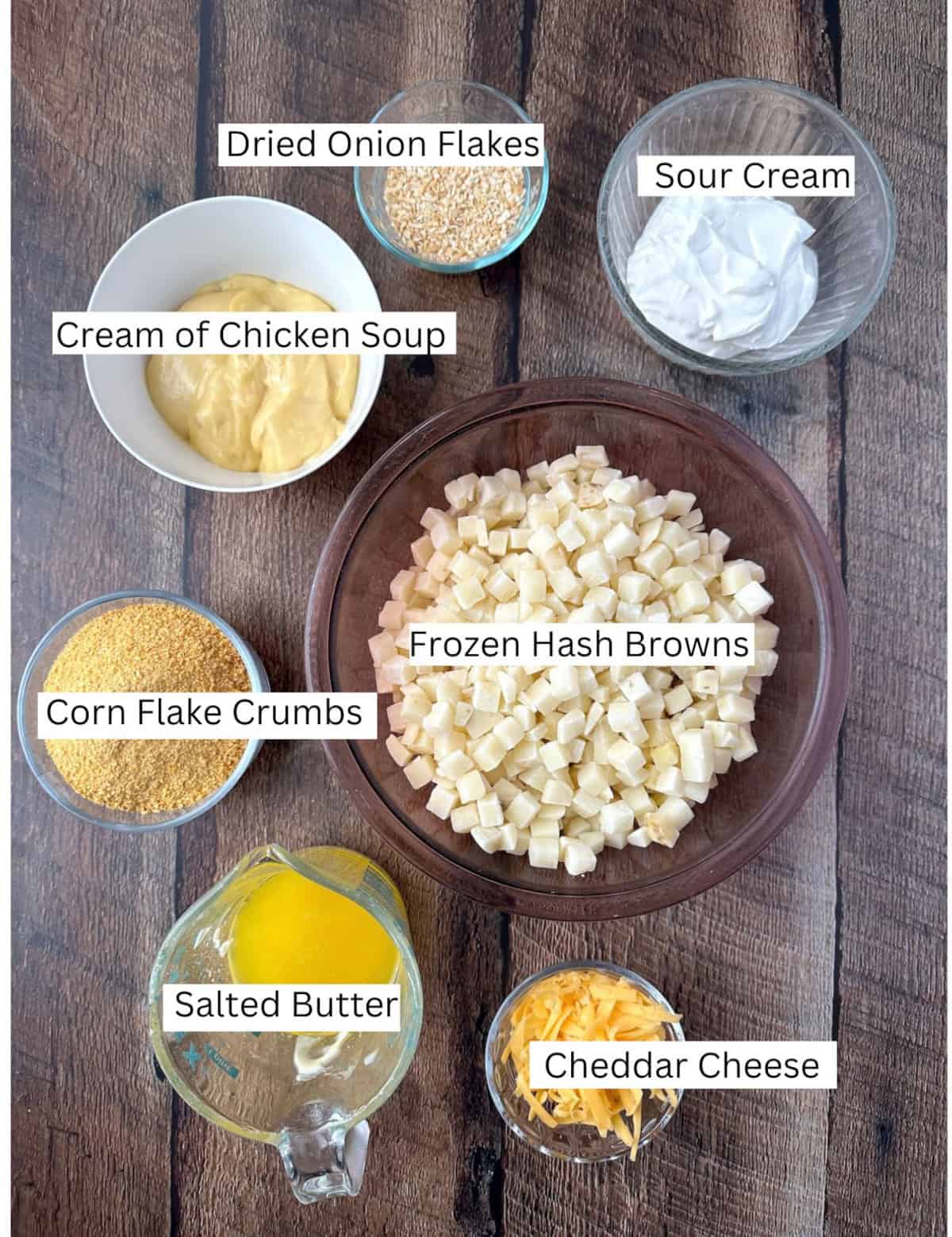 Ingredients for country potatoes in small bowls on a wooden table top.