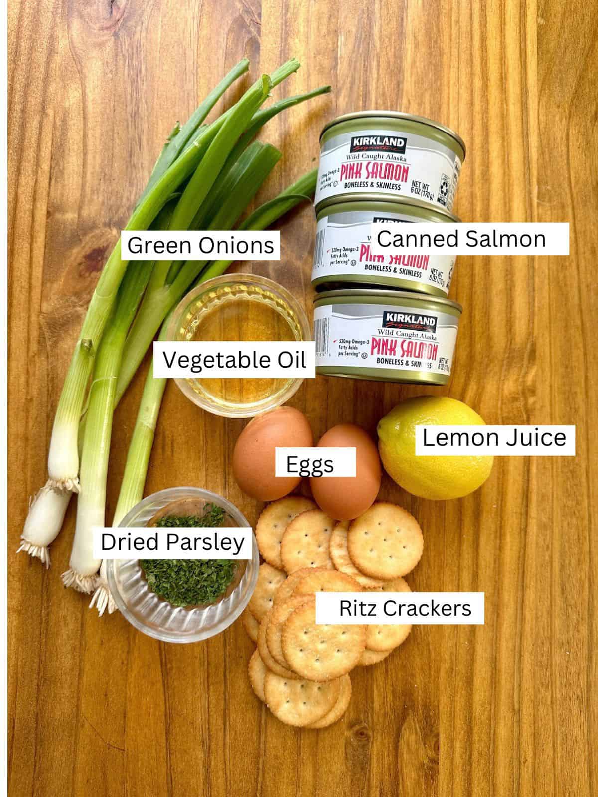 Ingredients for salmon patties with labels on a wooden table.