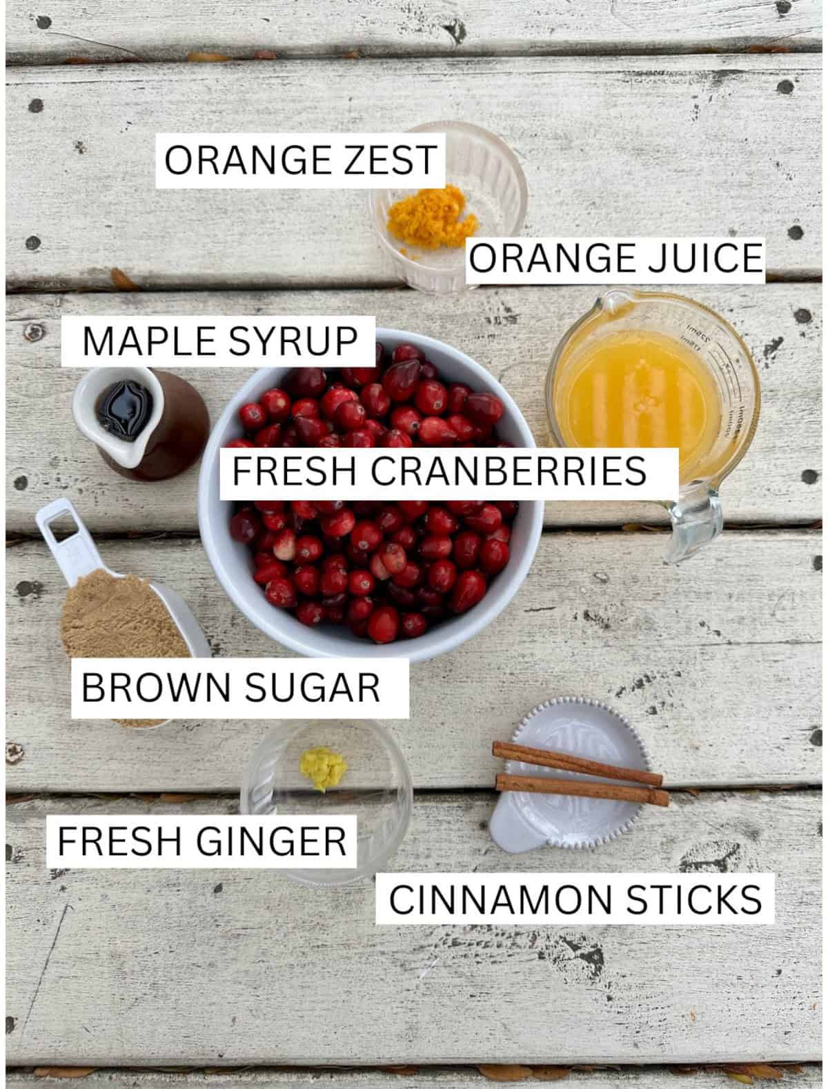 Ingredients for Orange Cranberry Sauce in small containers on a table.