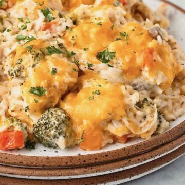 A plate with chicken, rice and melted cheese.