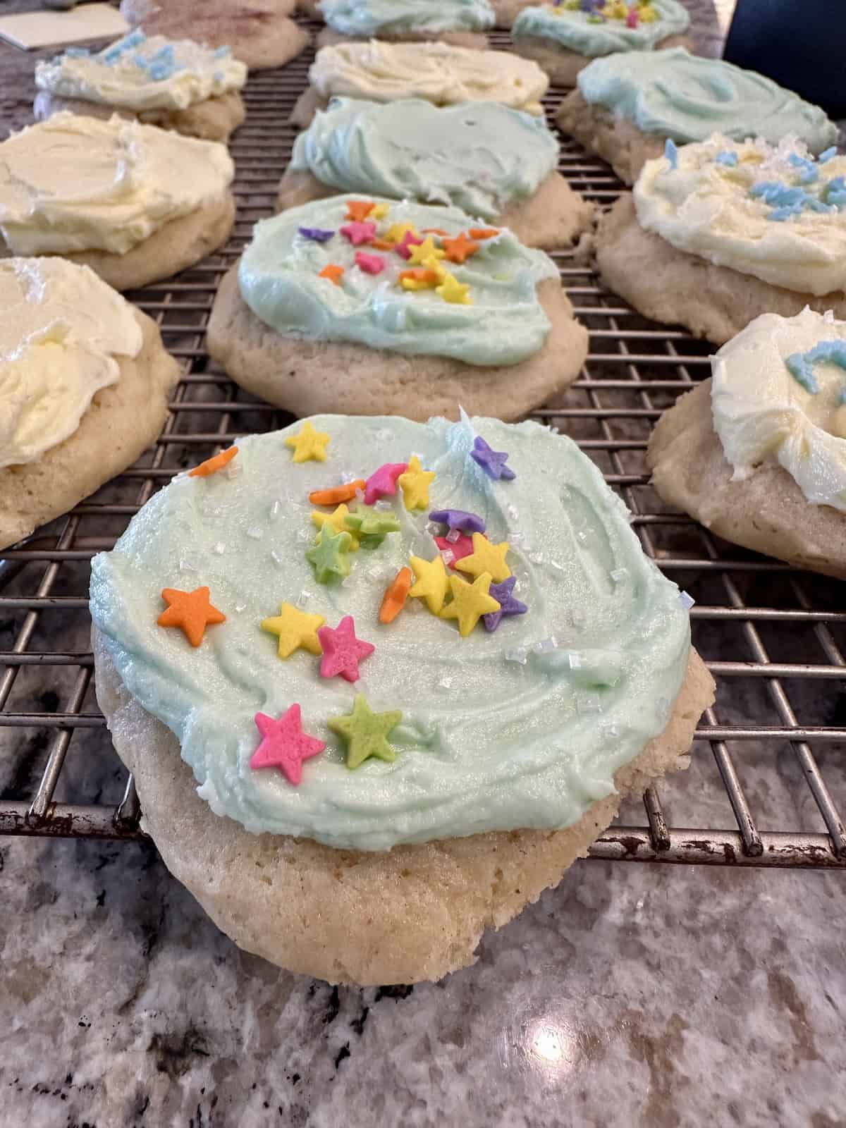 Frosted cookies on a cooling rack.