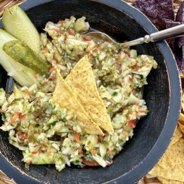 A bowl of pickle de gallo in a basket of chips.