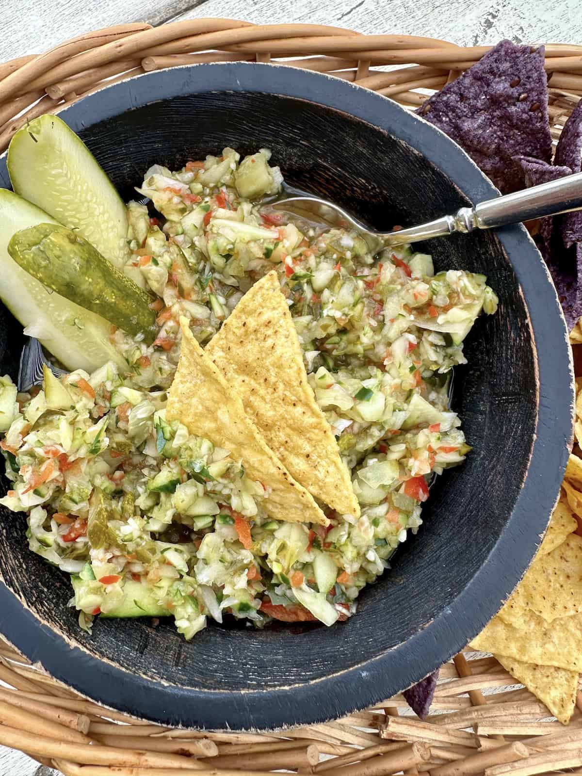 A bowl of pickle de gallo in a basket of chips.
