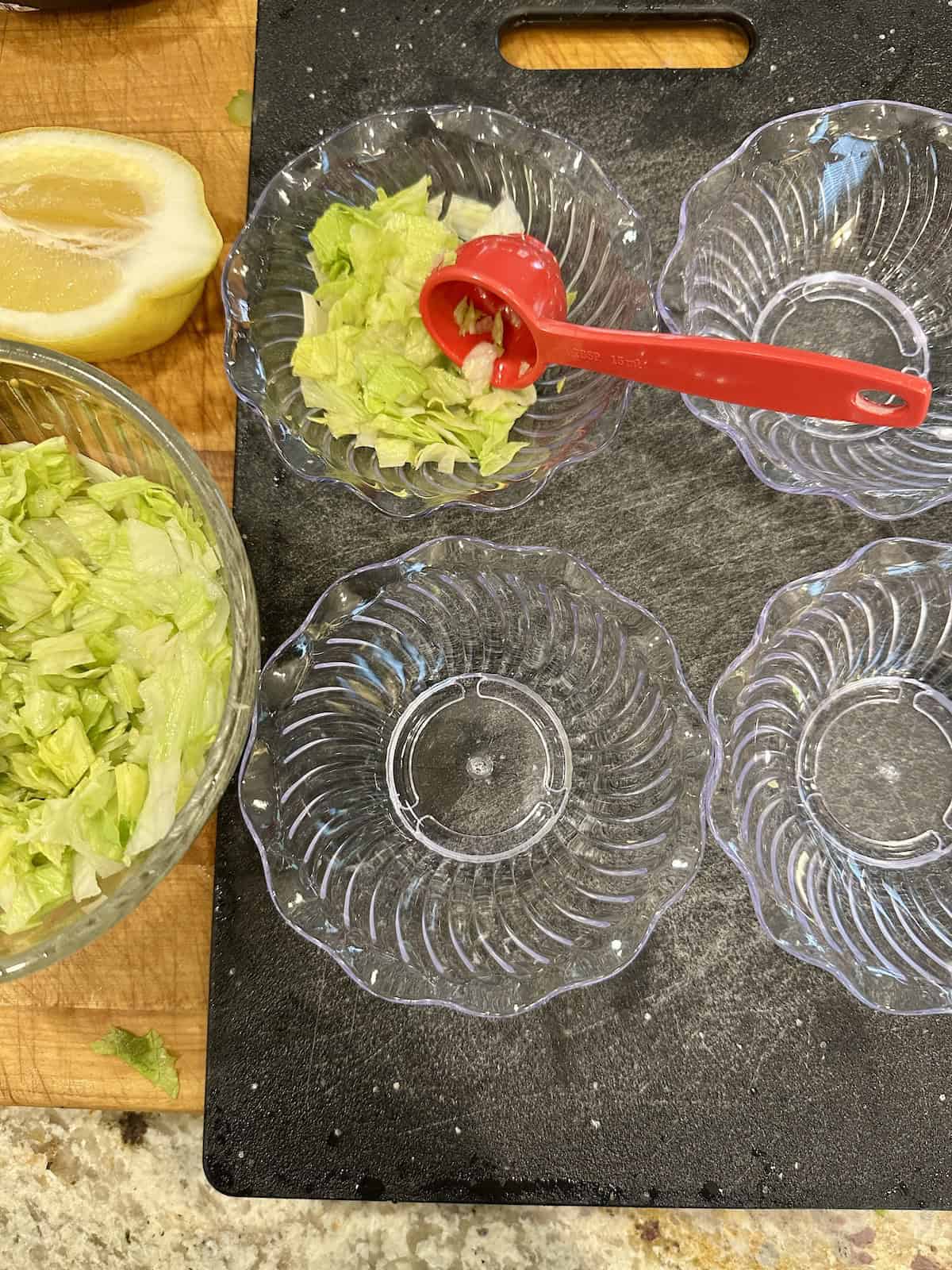 Small serving bowls with chopped lettuce added to one of them.