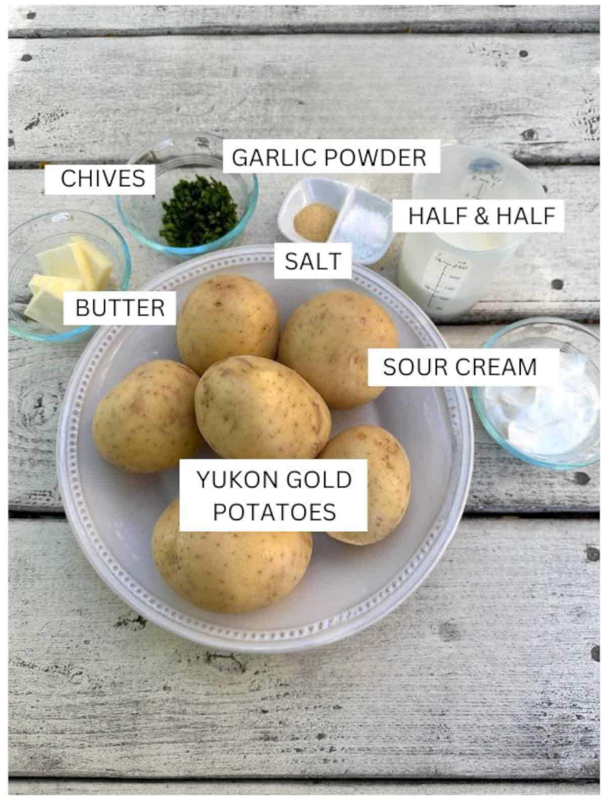 Labeled ingredients for yukon gold mashed potatoes in small bowls on a table.