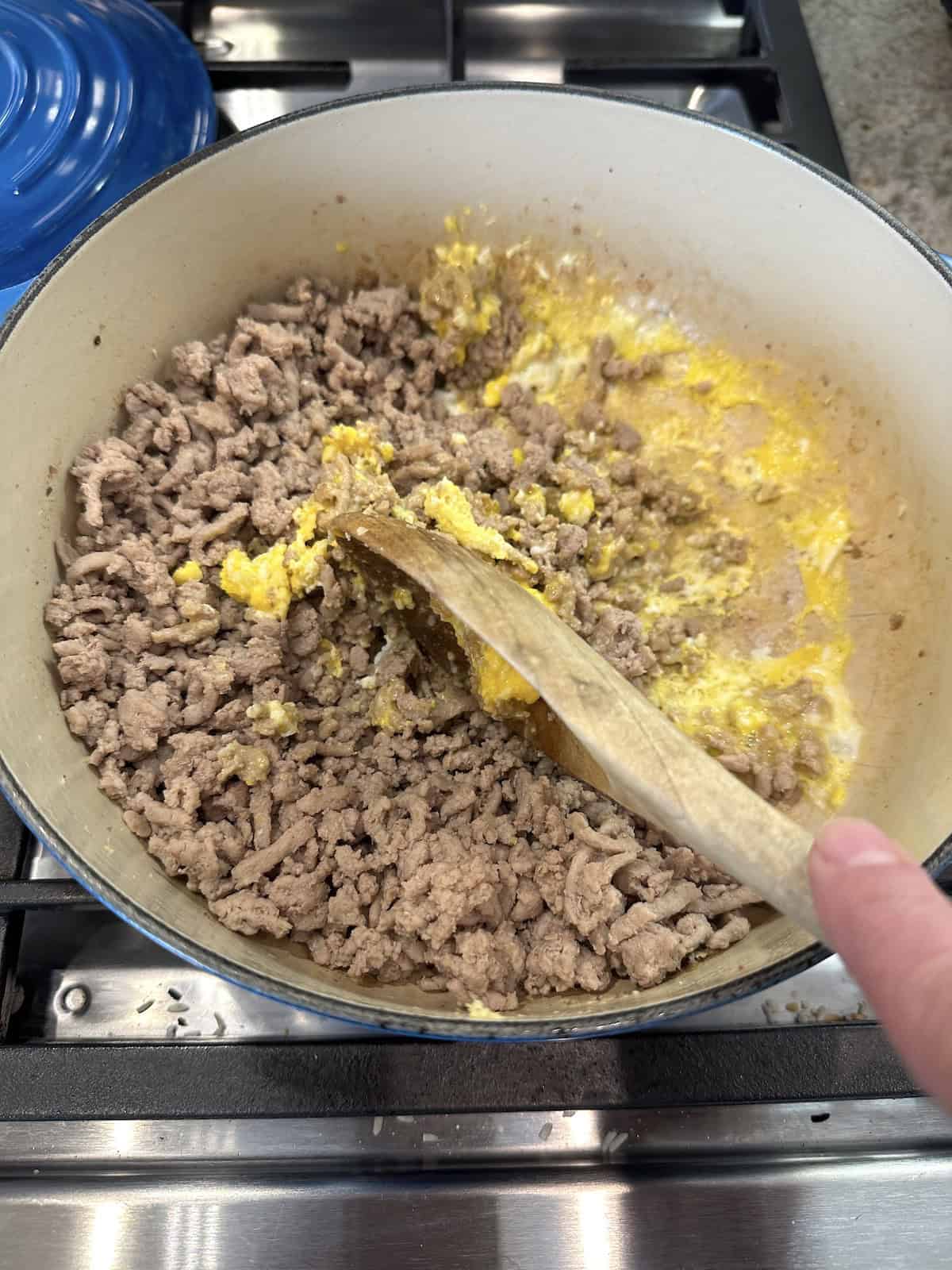 Cooked turkey in a pan on the stove with a partially cooked egg.