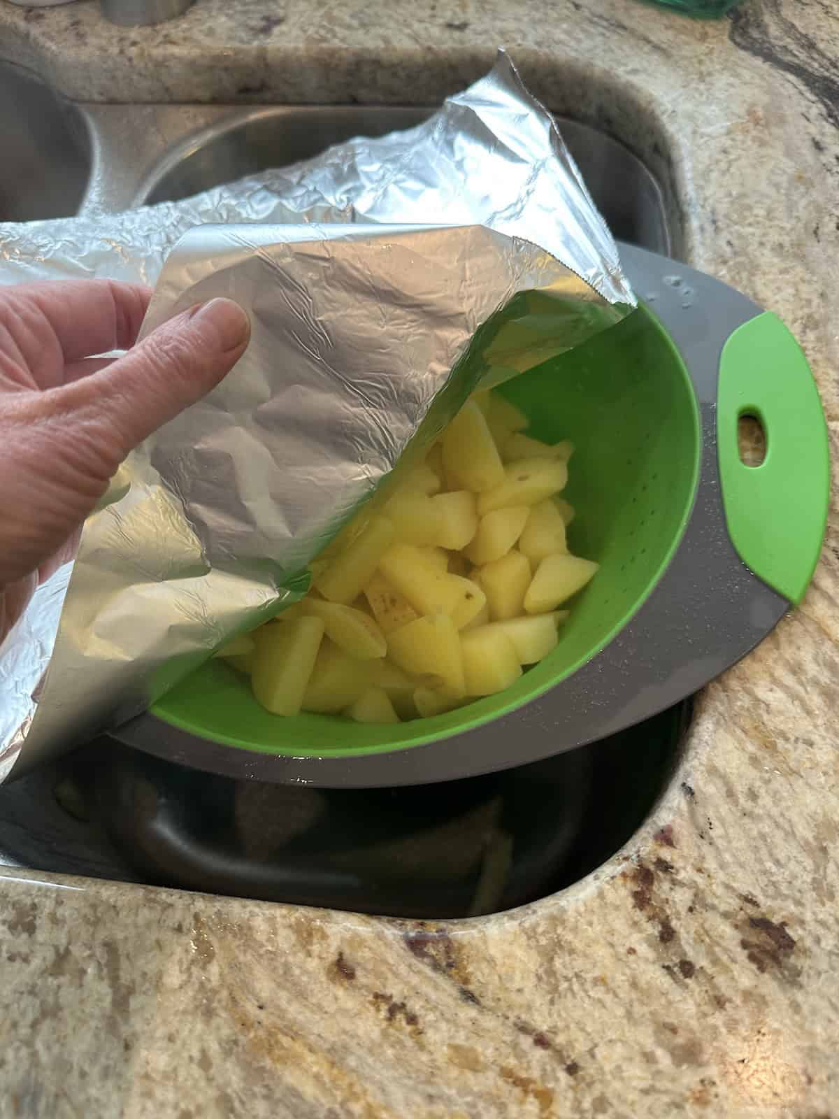 Drained potatoes in a colander over the sink.