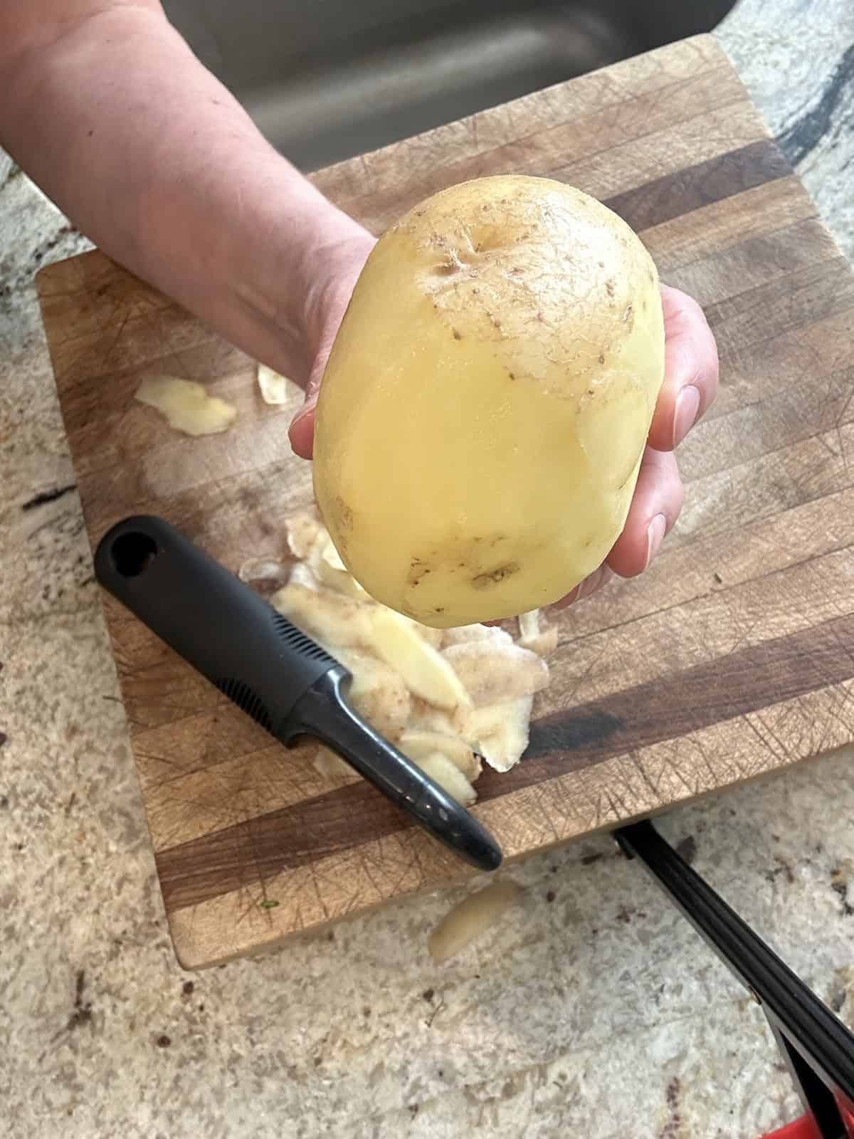 A yukon gold potato, partially peeled.