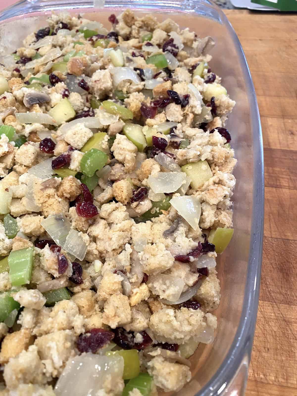 A casserole dish filled with stuffing and vegetables.