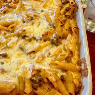 Layered pasta with beef, sauce and melted cheese in a baking dish.