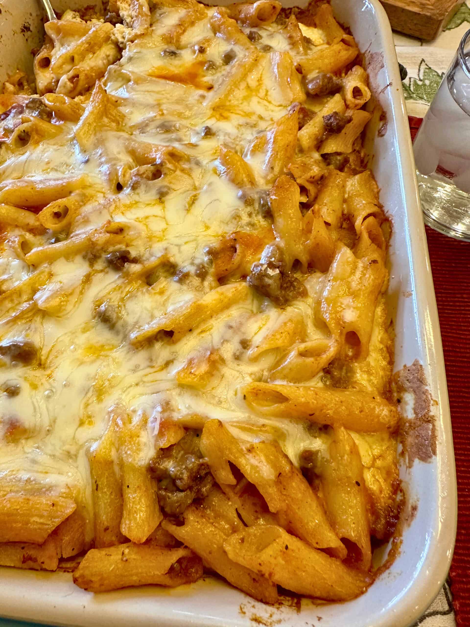 Layered pasta with beef, sauce and melted cheese in a baking dish.