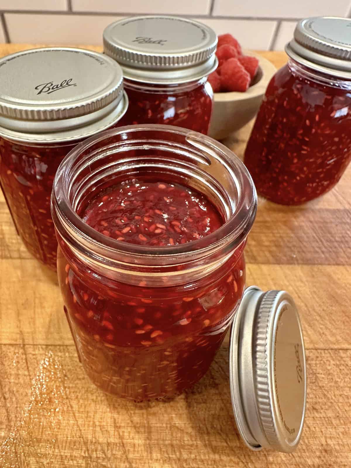 Easy small batch raspberry jam in jars with lids.