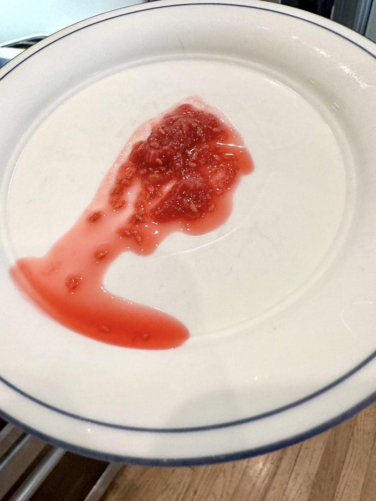 A raspberry jam on a cold plate with liquid.