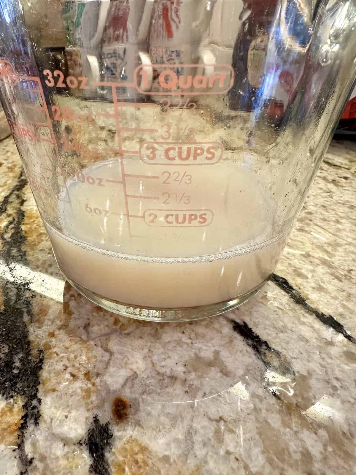 Canned clam juice in a measuring cup.