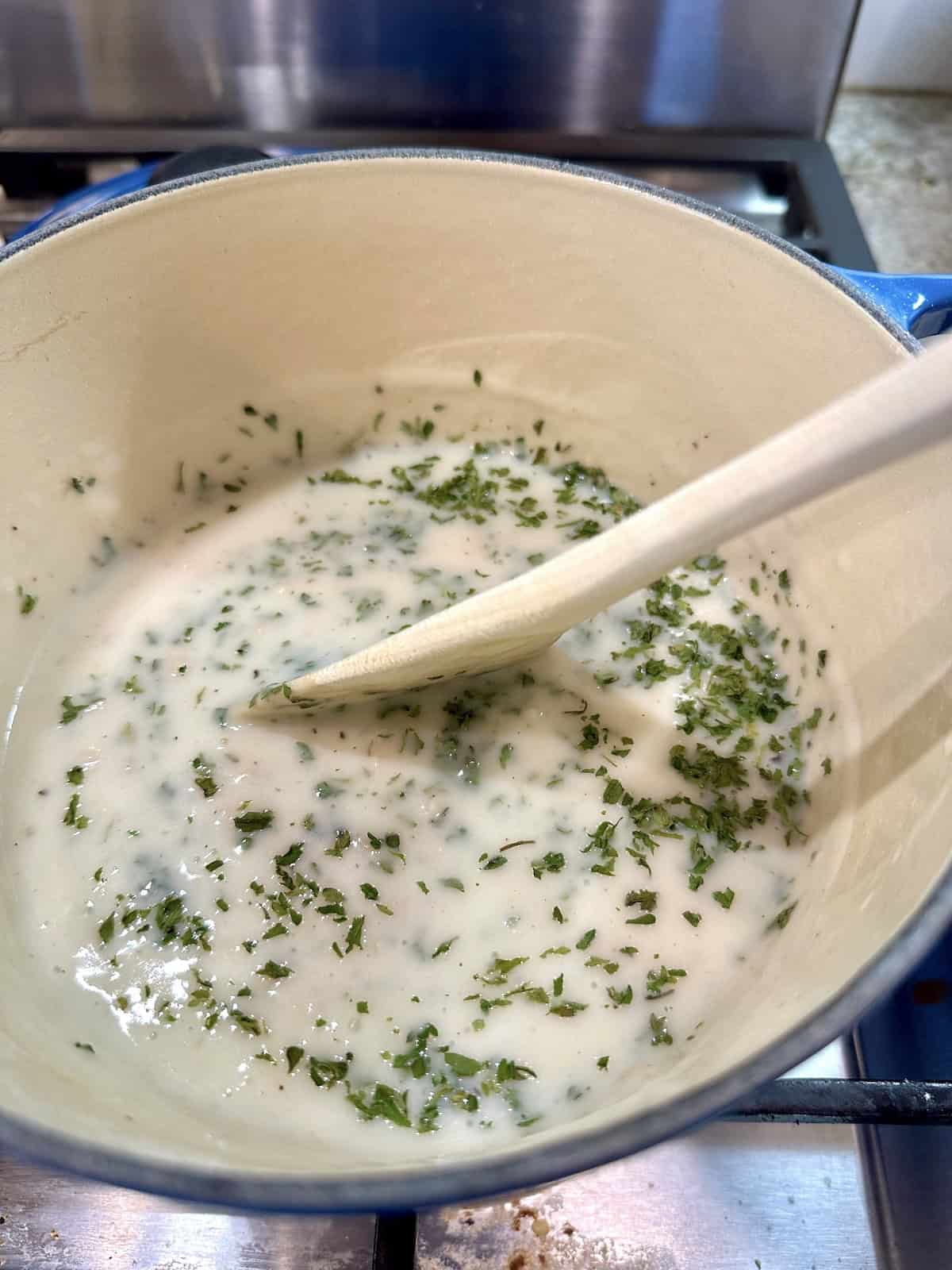 Clam sauce in a pan on the stove with parsley.